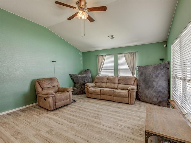 living area featuring visible vents, ceiling fan, light wood-style floors, and vaulted ceiling