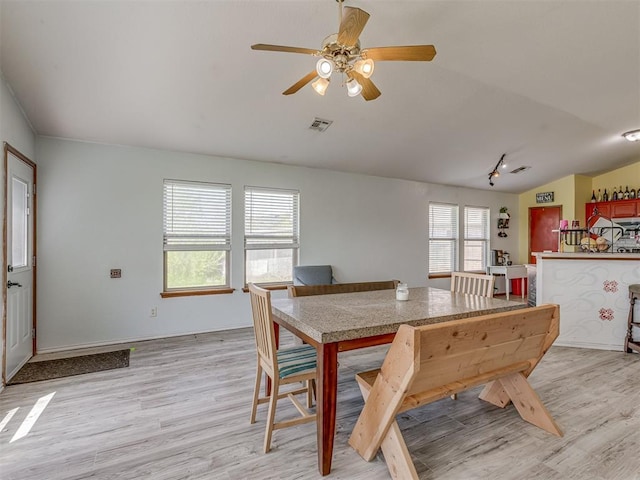 dining space with light wood-type flooring, visible vents, ceiling fan, and lofted ceiling