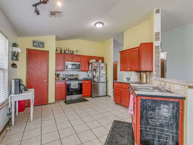 kitchen with visible vents, light tile patterned floors, a sink, appliances with stainless steel finishes, and lofted ceiling