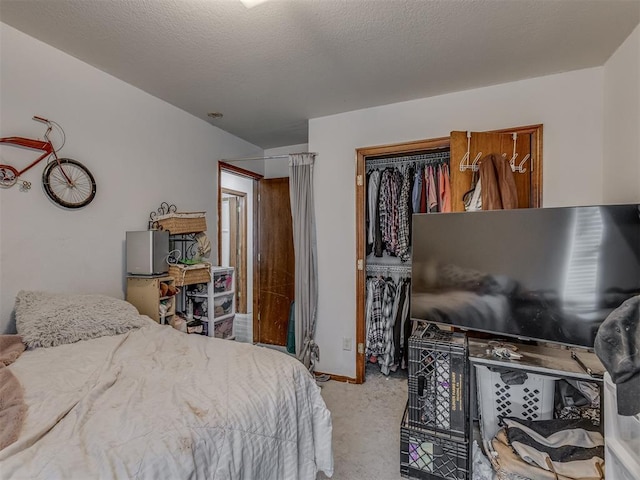 carpeted bedroom featuring a textured ceiling and a closet