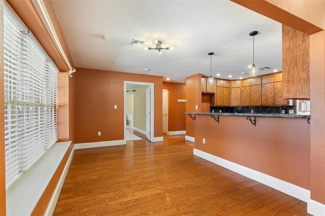 17787 N County Road 3200th Rd, Pauls Valley, OK 73075 - kitchen featuring light wood-style floors, a peninsula, visible vents, a breakfast bar, and hanging light fixtures