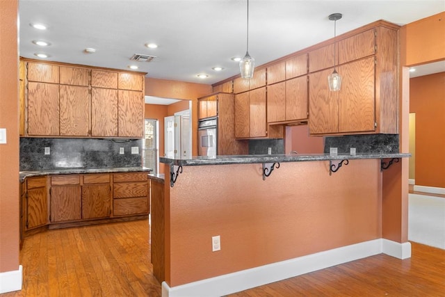 17787 N County Road 3200th Rd, Pauls Valley, OK 73075 - kitchen with light wood-style flooring, visible vents, a breakfast bar area, and stainless steel oven