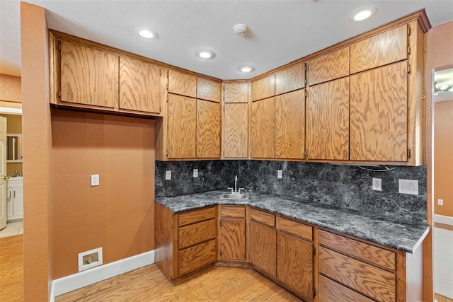 17787 N County Road 3200th Rd, Pauls Valley, OK 73075 - kitchen with tasteful backsplash, baseboards, a sink, dark countertops, and light wood-style floors