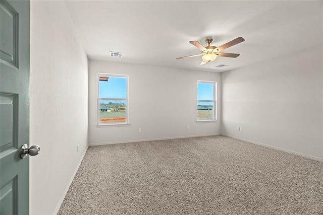 unfurnished room featuring baseboards, visible vents, ceiling fan, and carpet flooring