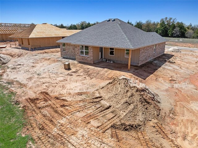 rear view of property with a shingled roof