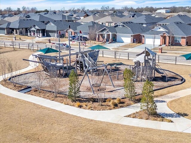 surrounding community featuring a garage, a residential view, concrete driveway, and fence