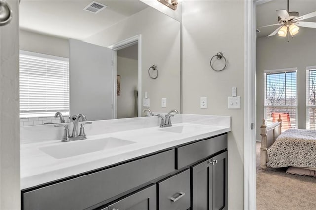 bathroom featuring a sink, ceiling fan, double vanity, ensuite bath, and visible vents