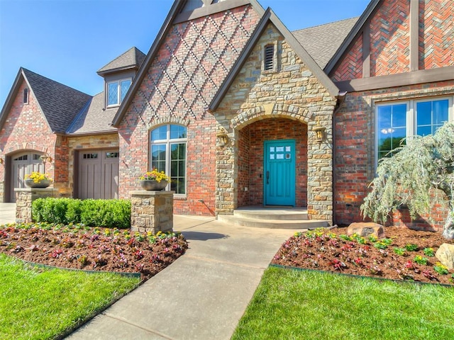 view of front of house with a garage, a shingled roof, stone siding, and brick siding