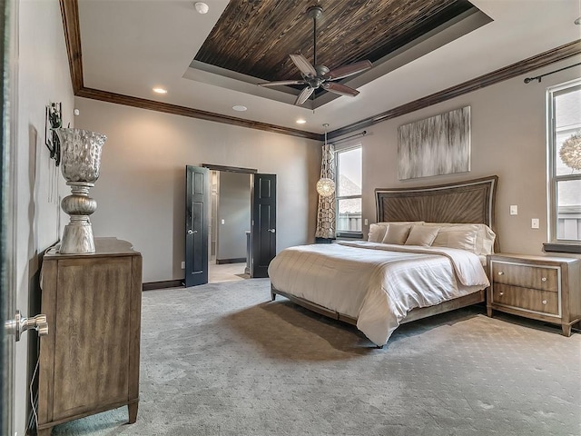 bedroom featuring ornamental molding, baseboards, light colored carpet, a raised ceiling, and a ceiling fan