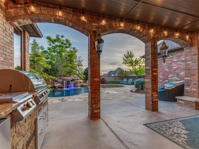 view of patio / terrace with area for grilling, exterior kitchen, fence, and a fenced in pool