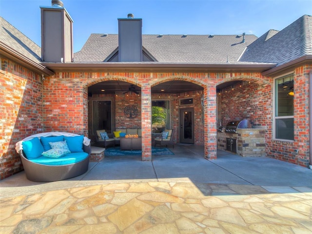 view of patio / terrace with exterior kitchen, an outdoor hangout area, and a grill