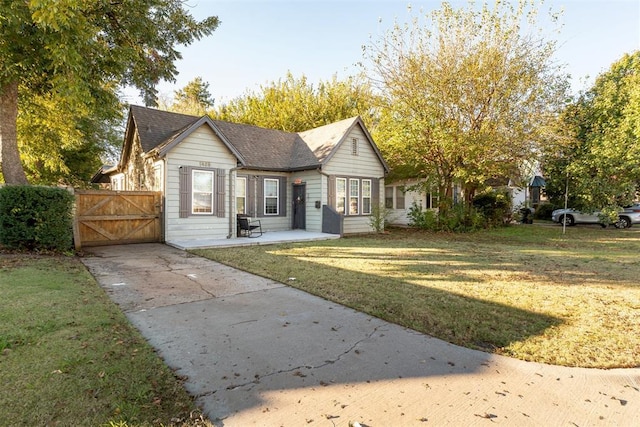 1428 NW 45th St, Oklahoma City, OK 73118 - view of front facade featuring a gate, concrete driveway, fence, a front yard, and roof with shingles