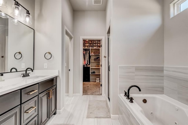 1219 N Adair Ct, Stillwater, OK 74075 - bathroom with a whirlpool tub, double vanity, a spacious closet, visible vents, and a sink