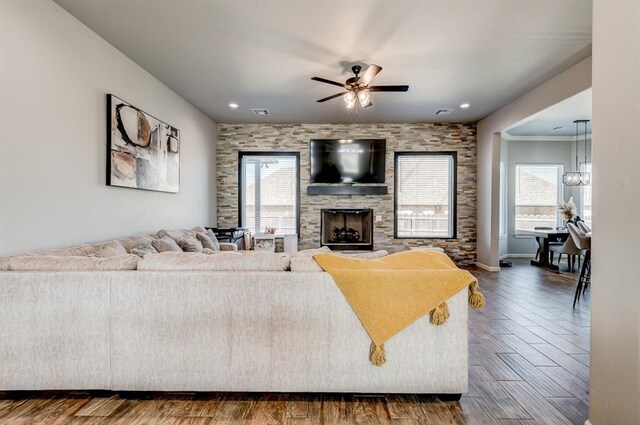 1219 N Adair Ct, Stillwater, OK 74075 - living area featuring visible vents, baseboards, a fireplace, ceiling fan with notable chandelier, and dark wood-type flooring