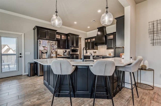 1219 N Adair Ct, Stillwater, OK 74075 - kitchen with custom exhaust hood, glass insert cabinets, a sink, a peninsula, and light wood finished floors