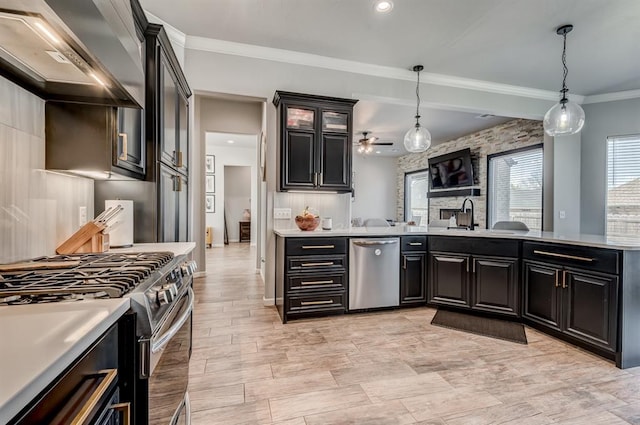 1219 N Adair Ct, Stillwater, OK 74075 - kitchen with wall chimney exhaust hood, ornamental molding, a ceiling fan, light countertops, and stainless steel appliances