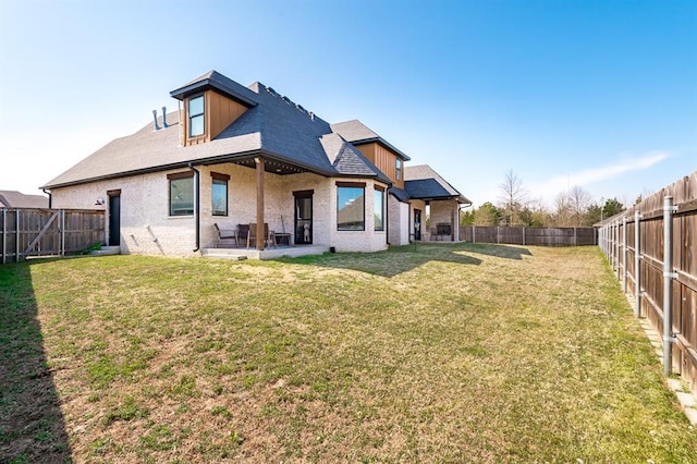 1219 N Adair Ct, Stillwater, OK 74075 - rear view of house featuring a patio, brick siding, a fenced backyard, and a lawn