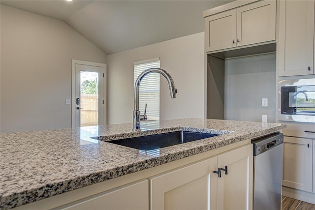 4980 12th Ave, Goldsby, OK 73093 - kitchen with a sink, stainless steel dishwasher, light stone countertops, vaulted ceiling, and wood finished floors