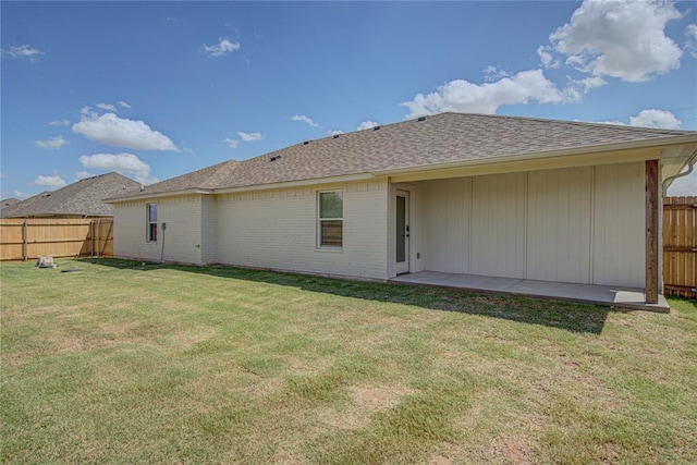 4980 12th Ave, Goldsby, OK 73093 - rear view of property featuring a shingled roof, brick siding, and a patio area