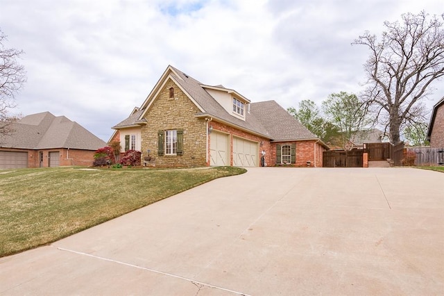 3615 S Scissortail Dr, Stillwater, OK 74074 - view of front of house featuring concrete driveway, fence, stone siding, and a front lawn