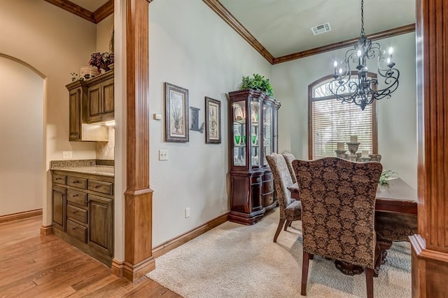 3615 S Scissortail Dr, Stillwater, OK 74074 - dining room with an inviting chandelier, light wood-style flooring, ornamental molding, visible vents, and baseboards