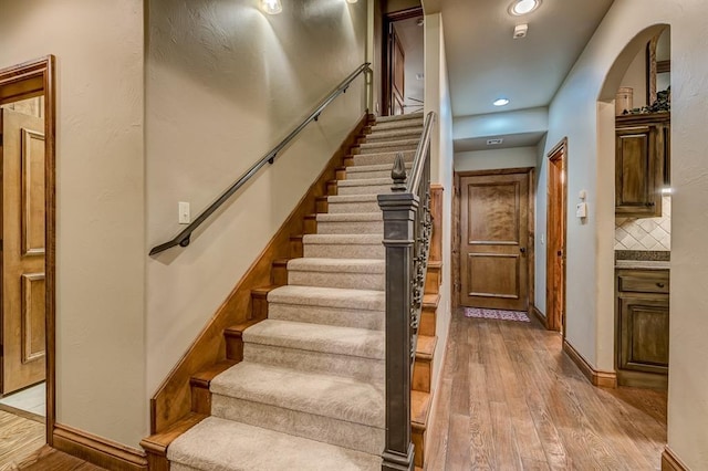 3615 S Scissortail Dr, Stillwater, OK 74074 - stairs featuring arched walkways, recessed lighting, baseboards, and hardwood / wood-style flooring
