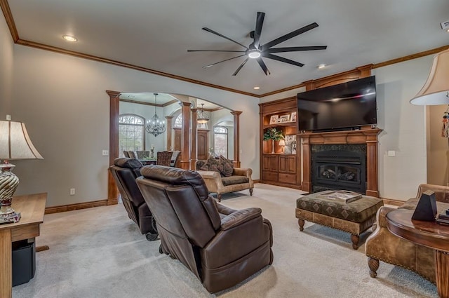 3615 S Scissortail Dr, Stillwater, OK 74074 - carpeted living room with ceiling fan with notable chandelier, decorative columns, a fireplace, arched walkways, and baseboards