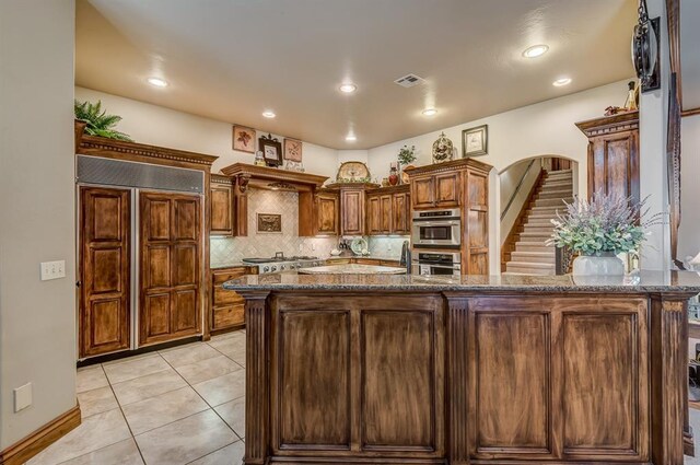 3615 S Scissortail Dr, Stillwater, OK 74074 - kitchen with dark stone countertops, visible vents, tasteful backsplash, light tile patterned floors, and stainless steel appliances