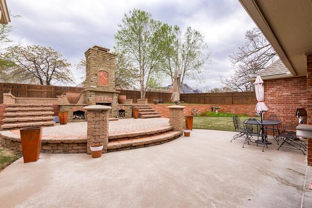 3615 S Scissortail Dr, Stillwater, OK 74074 - view of patio / terrace featuring a fenced backyard and a fireplace