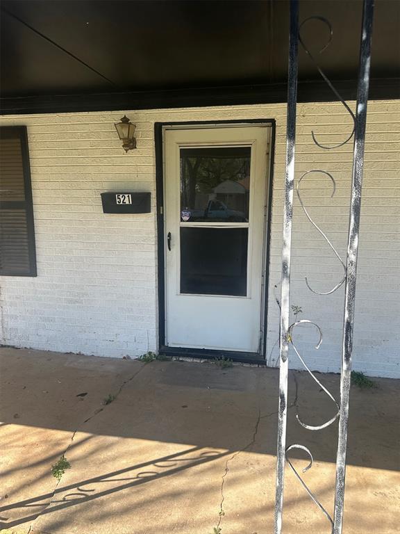 view of exterior entry featuring brick siding