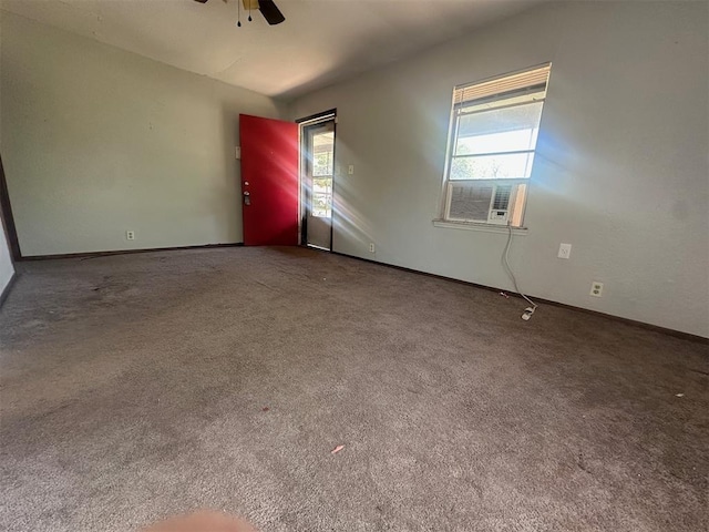carpeted spare room featuring ceiling fan, baseboards, and plenty of natural light