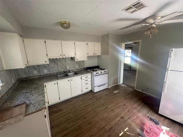kitchen featuring dark wood-style floors, visible vents, a sink, and white appliances
