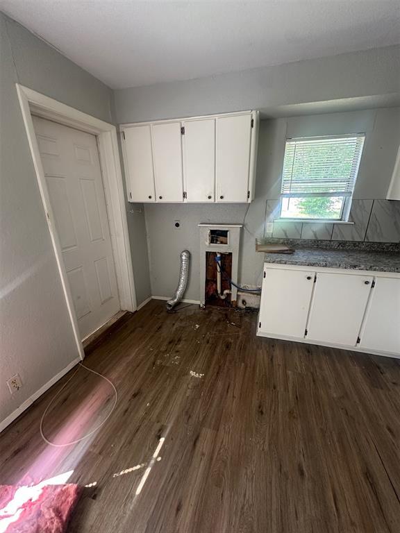 interior space with white cabinets, dark countertops, baseboards, and dark wood-style floors