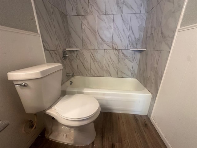 bathroom featuring toilet, shower / bathtub combination, and wood finished floors