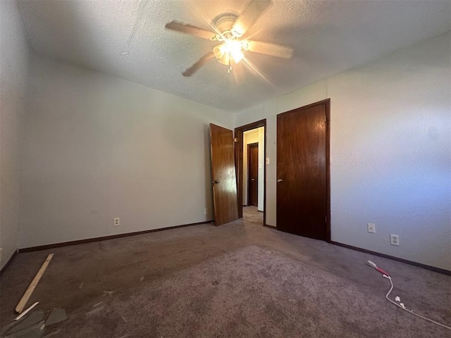 carpeted spare room with a textured ceiling, a ceiling fan, and baseboards