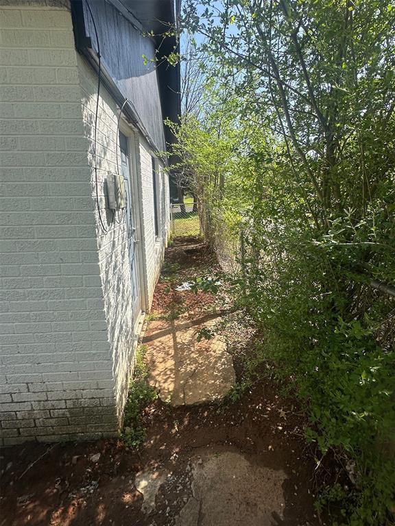 view of home's exterior featuring brick siding and fence