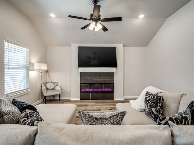 living room with baseboards, vaulted ceiling, a ceiling fan, and wood finished floors