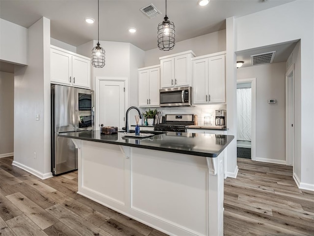 kitchen featuring a sink, visible vents, appliances with stainless steel finishes, and dark countertops