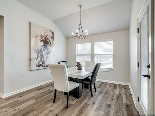 dining room featuring baseboards, vaulted ceiling, an inviting chandelier, and light wood-style floors