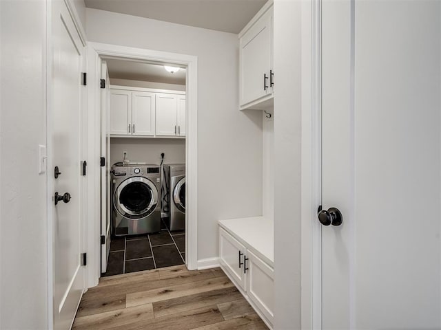 laundry room featuring independent washer and dryer, light wood finished floors, and cabinet space
