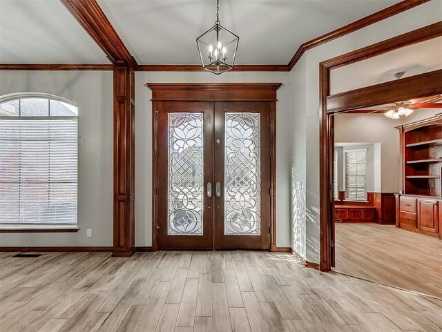 1217 Camelot Dr, Yukon, OK 73099 - foyer with crown molding, french doors, light wood-style floors, and visible vents