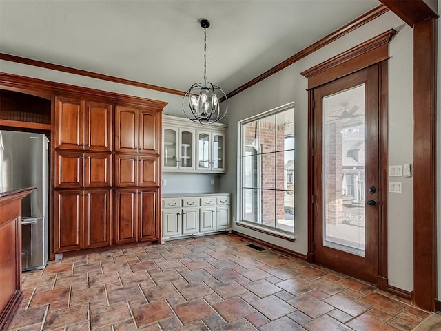 1217 Camelot Dr, Yukon, OK 73099 - unfurnished dining area with crown molding, an inviting chandelier, stone finish flooring, baseboards, and visible vents