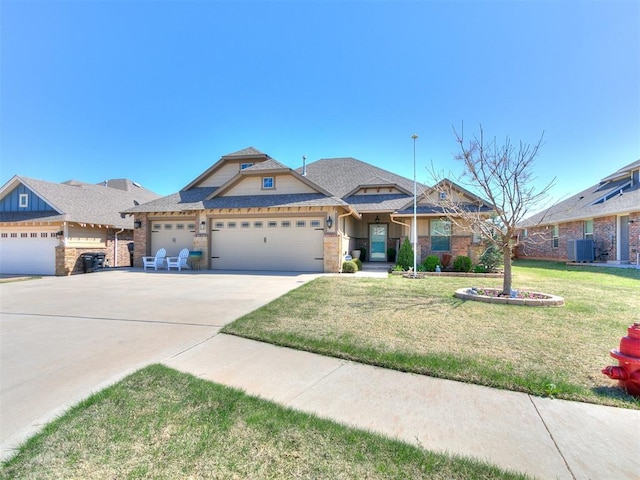 craftsman-style house with an attached garage, driveway, a front yard, and central air condition unit
