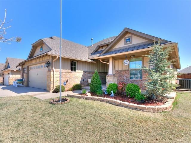 craftsman-style home with a garage, roof with shingles, and a front yard