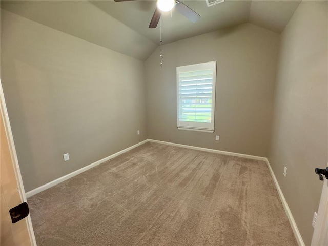 spare room featuring ceiling fan, vaulted ceiling, and carpet