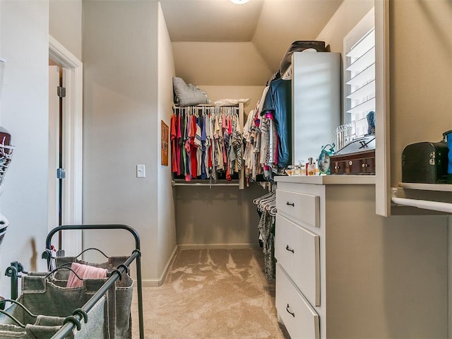 spacious closet with light carpet and vaulted ceiling