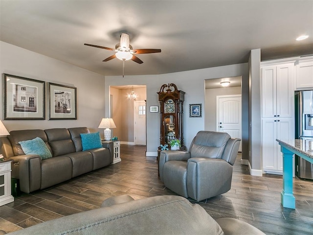 living room with recessed lighting, dark wood finished floors, baseboards, and ceiling fan with notable chandelier