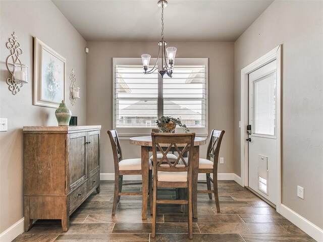 dining area featuring dark wood-type flooring, baseboards, and a chandelier