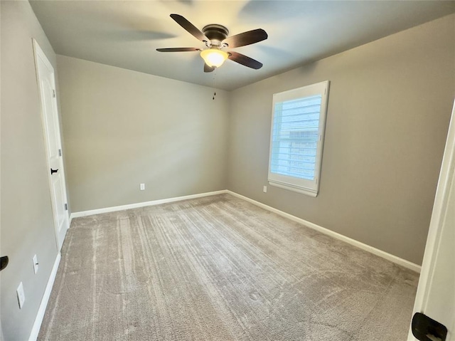 spare room featuring ceiling fan, baseboards, and carpet