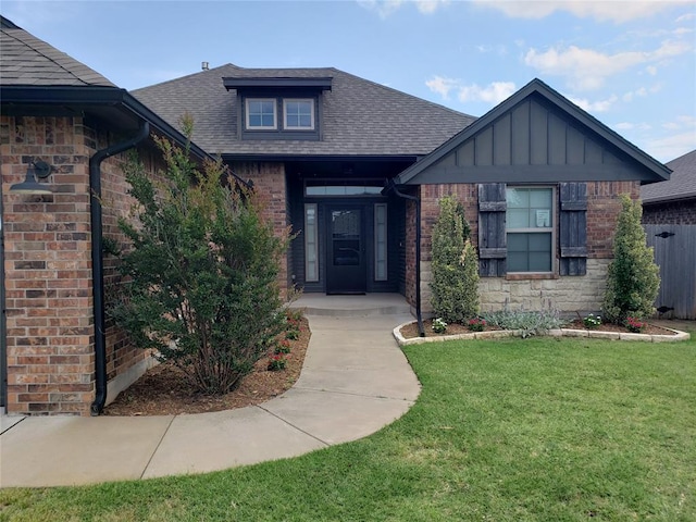 9908 SW 22nd St, Yukon, OK 73099 - view of front of home with brick siding, a front yard, roof with shingles, and board and batten siding